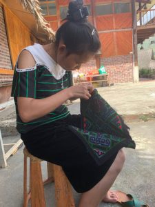 Hmong local embroidering a handmade belt